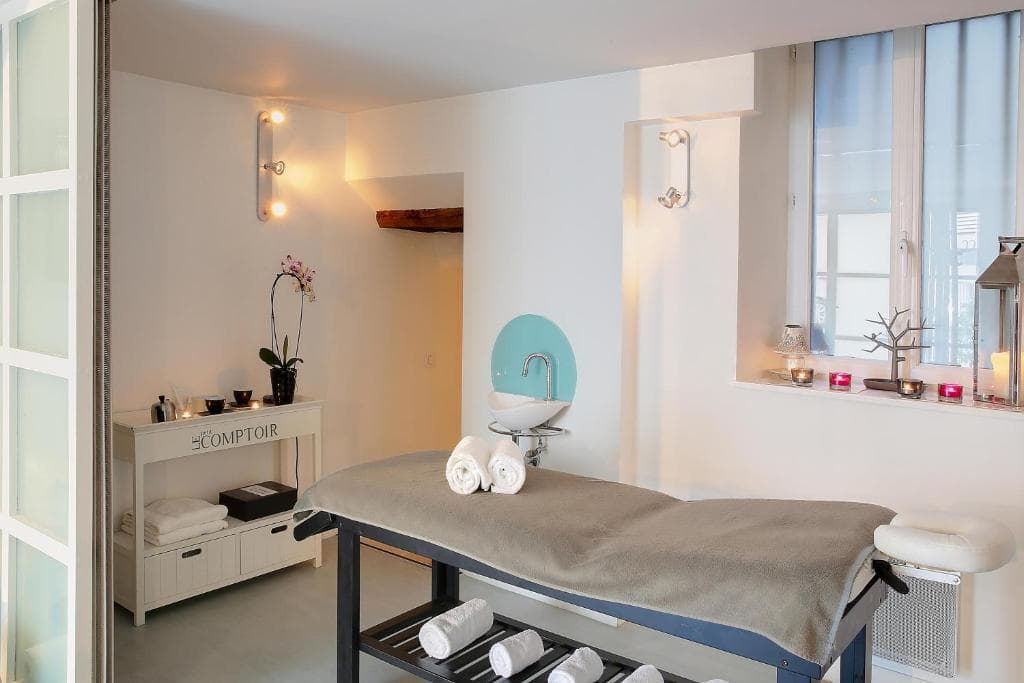 Cabine de soins du spa avec bougies, orchidée et serviettes blanches